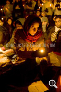 Photograph of a mourner lifting her gaze at a candlelight vigil for victims of Mumbai, Aldwych, 2009